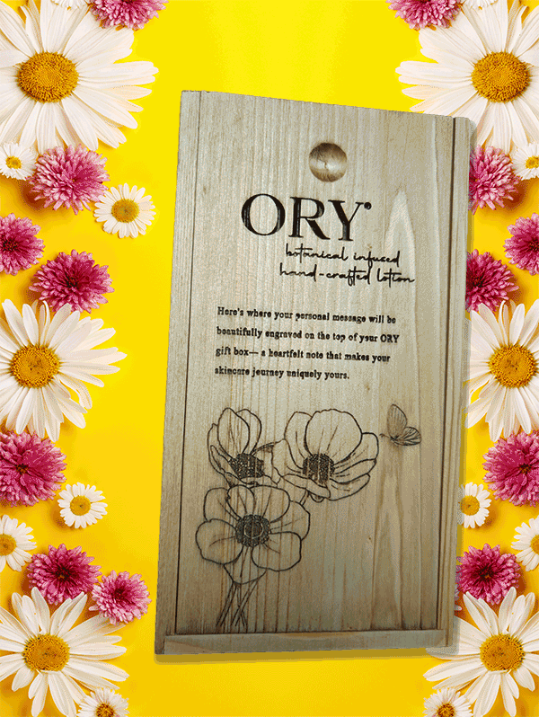 ORY Wooden Gift Box with Custom Engraving | Botanical Skincare Gift Packaging ORY wooden gift box with engraved logo and floral illustration, displayed on a vibrant yellow background framed by daisies and pink flowers, highlighting personalized botanical skincare gifting.