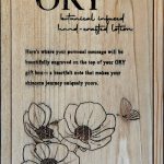 ORY wooden gift box lid with engraved logo, floral illustration, and personalized message space, showcasing handcrafted botanical skincare packaging.