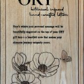 ORY wooden gift box lid with engraved logo, floral illustration, and personalized message space, showcasing handcrafted botanical skincare packaging.