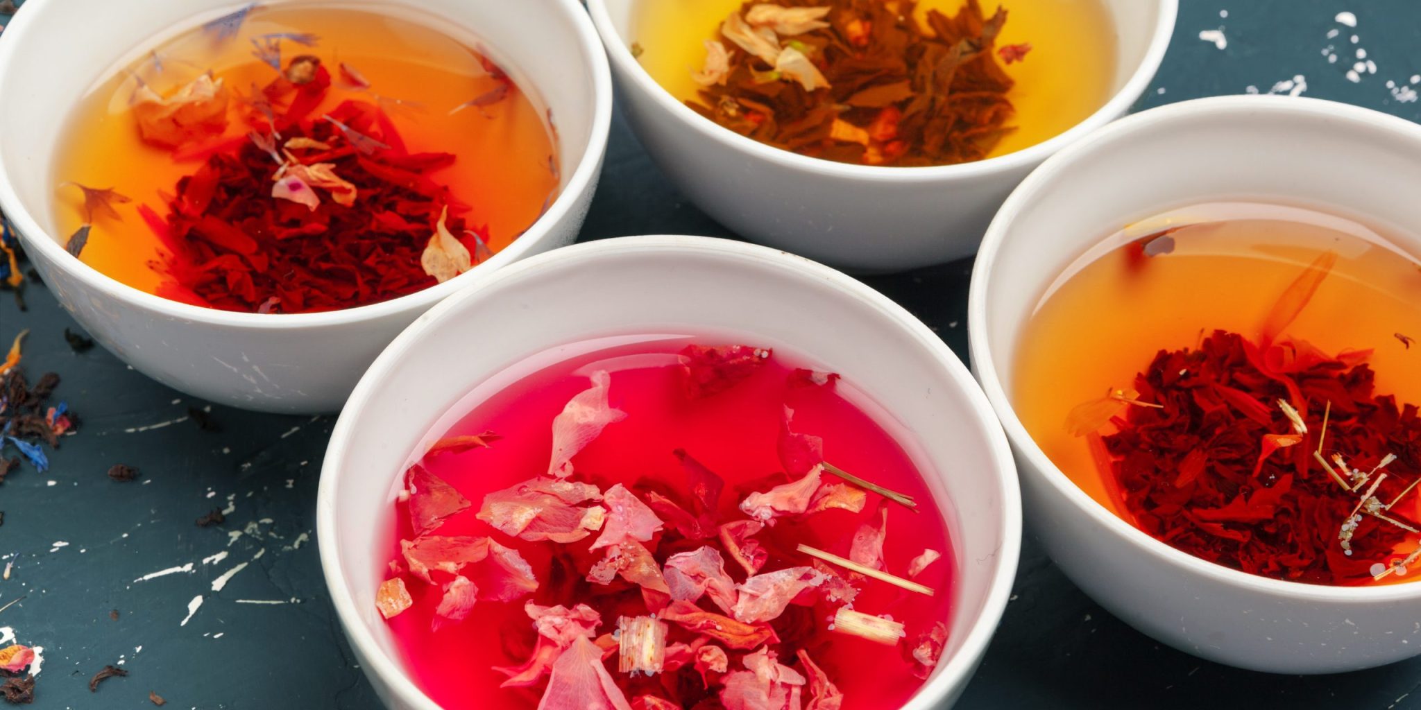 Natural botanical colorants steeped in liquid form, showcasing plant-based hues used in skincare formulations for function, sensorial experience, and visual balance.