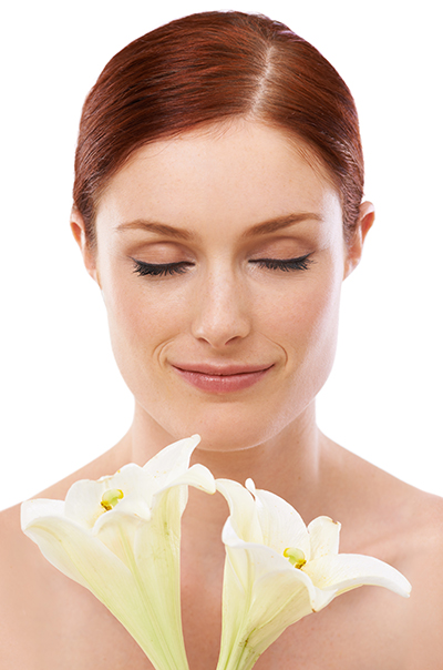 beauty_photoshoot_cleanser_sensitive_skin Woman with sensitive skin gently holding white lilies, symbolizing ORY Skincare’s gentle botanical cleanser for sensitive skin.